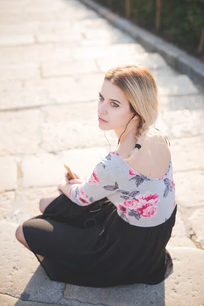 Mujer rubia escuchando música al aire libre — Foto de Stock