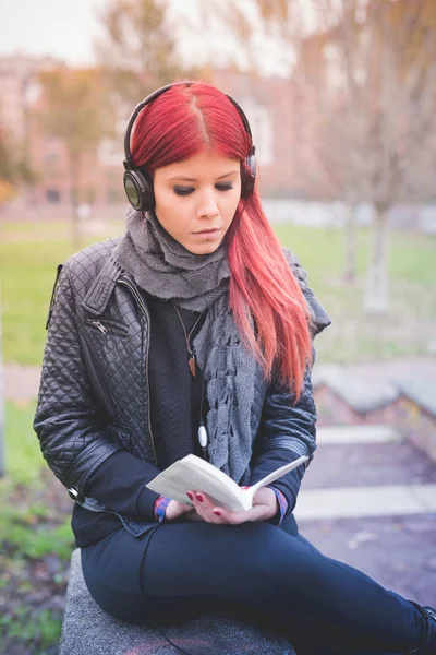 Vrouw luisteren muziek en lezen — Stockfoto