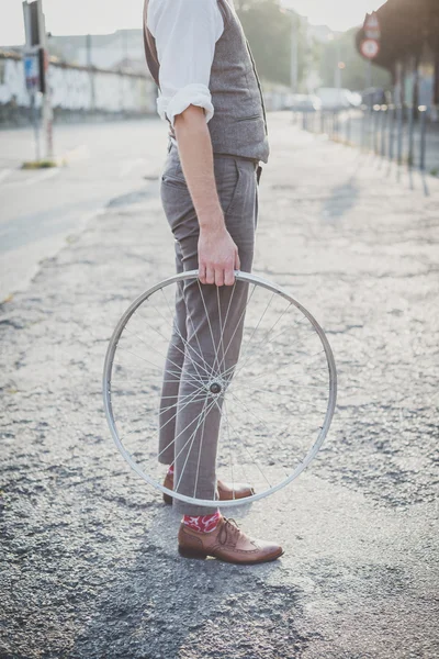 Hipster man holding old bicycle wheel — Stock Photo, Image