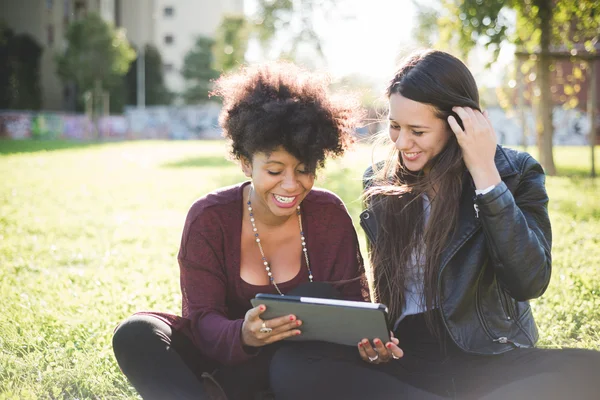 Two multiethnic girls with tablet — Stock Photo, Image