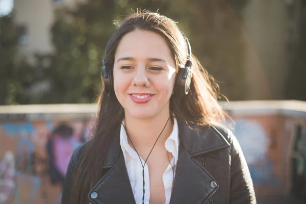 Jong meisje in stad luisteren muziek — Stockfoto