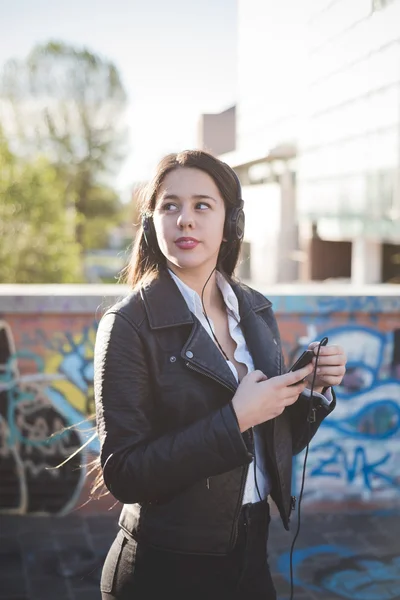 Jeune fille en ville écouter de la musique — Photo