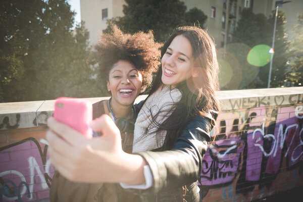 Two multiethnic girls taking selfie
