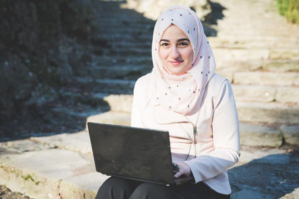 Mulher muçulmana no parque com laptop — Fotografia de Stock