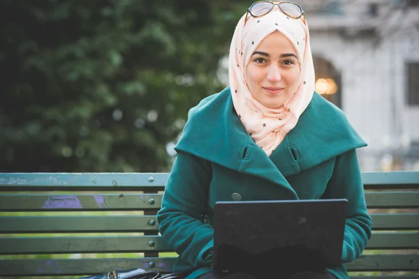 De moslimvrouw in het park met laptop — Stockfoto