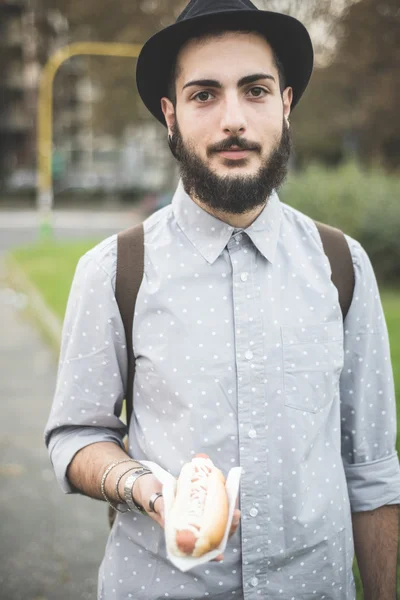 Modern man eating hot dog — Stock Photo, Image