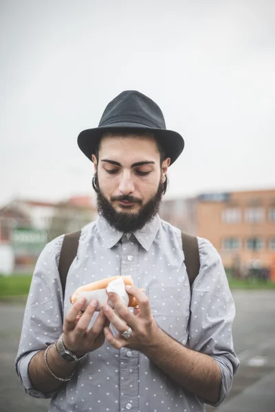 Modern man eating hot dog — Stock Photo, Image
