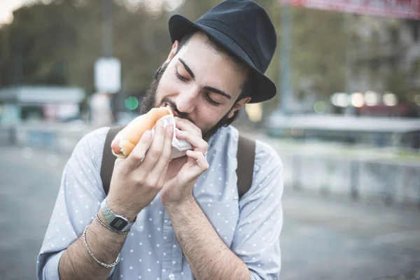 Modern man eating hot dog — Stock Photo, Image