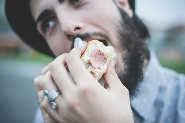 Hombre moderno comiendo hot dog — Foto de Stock
