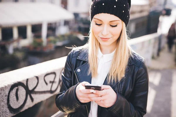 Hermosa mujer con teléfono inteligente en la ciudad — Foto de Stock