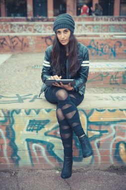 Tablet kullanan genç bir kadın.