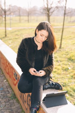 Tablet ve akıllı telefon kullanan genç güzel kadın