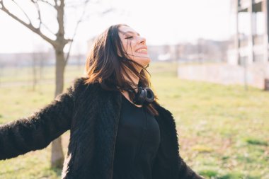 Genç ve güzel bir kadın kulaklıkla müzik dinliyor.
