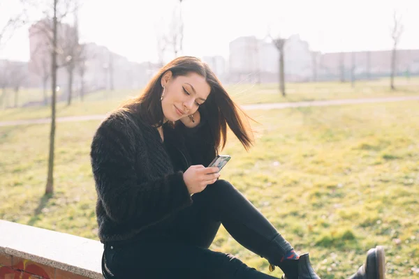 Mujer hermosa joven usando teléfono inteligente —  Fotos de Stock