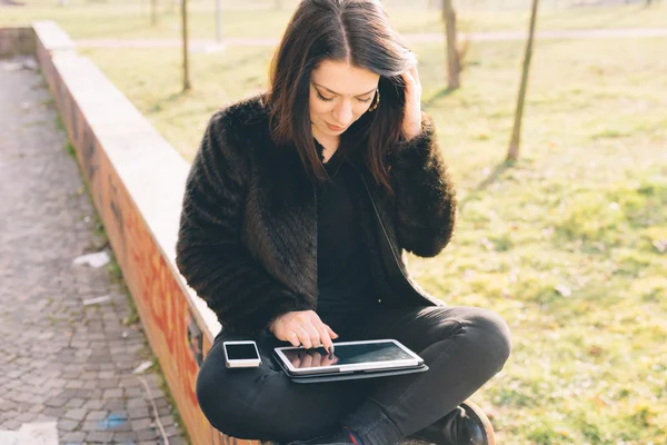 Jonge mooie vrouw met behulp van Tablet PC en smartphone — Stockfoto