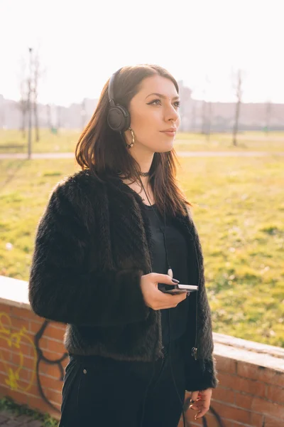 Jeune belle femme écouter de la musique avec des écouteurs — Photo