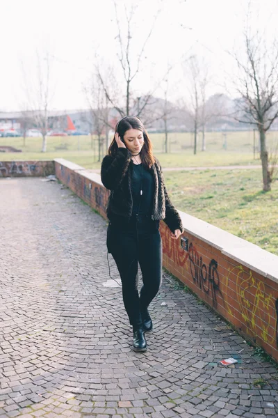 Junge schöne Frau hört Musik mit Kopfhörern — Stockfoto