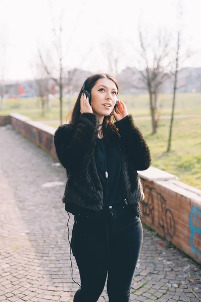 Молодая красивая женщина слушает музыку в наушниках — стоковое фото