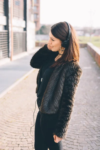 Giovane bella donna che ascolta musica con le cuffie — Foto Stock