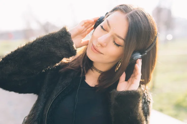 Joven hermosa mujer escuchando música con auriculares — Foto de Stock