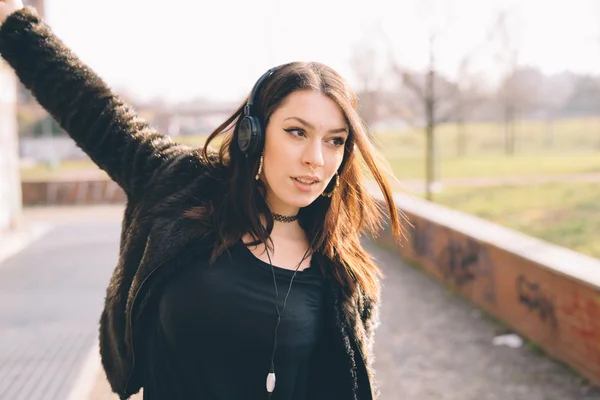 Ung vacker kvinna lyssnar på musik med hörlurar — Stockfoto