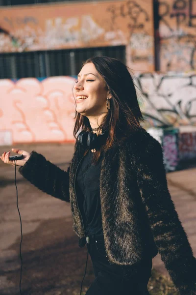 Jong mooi vrouw luisteren naar muziek met hoofdtelefoon — Stockfoto