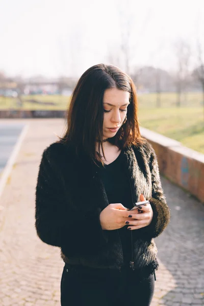 Mujer hermosa joven usando teléfono inteligente —  Fotos de Stock