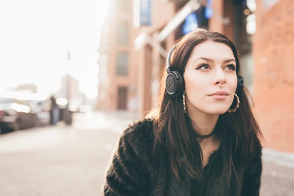 Ung vacker kvinna lyssnar på musik med hörlurar — Stockfoto