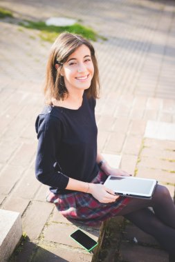 Tablet kullanan genç bir kadın.