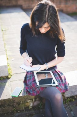 Tablet kullanan genç bir kadın.