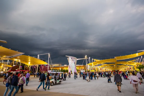 People visit universal exposition in evening time — Stock Photo, Image