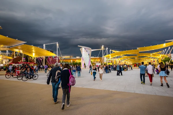 People visit universal exposition in evening time — Stock Photo, Image