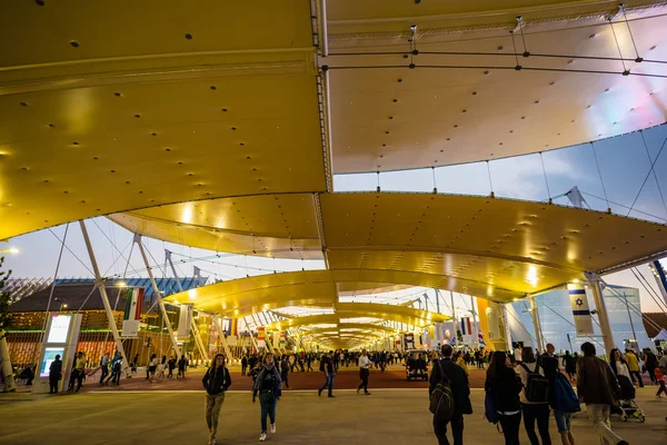 People visit universal exposition in evening time — Stock Photo, Image