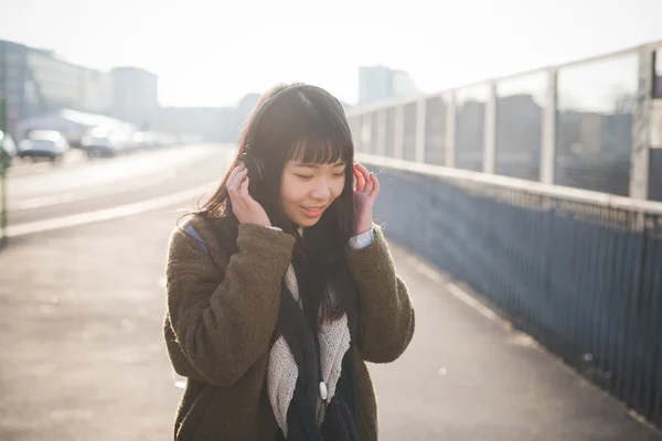 Joven mujer asiática con auriculares — Foto de Stock