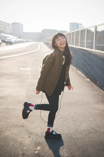 Jovem mulher asiática com fones de ouvido — Fotografia de Stock