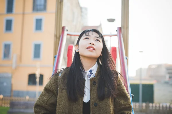 Asian woman in playground in city — Stock Photo, Image