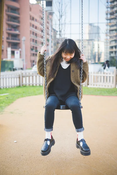 Young asian woman near swing — Stock Photo, Image