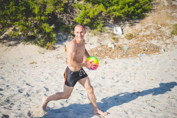 Man leker med boll på stranden — Stockfoto