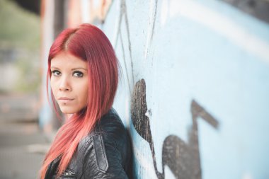 Young woman near graffiti wall