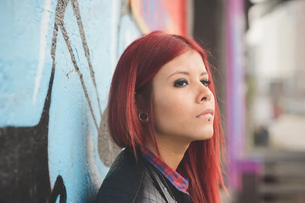 Young woman near graffiti wall — ストック写真