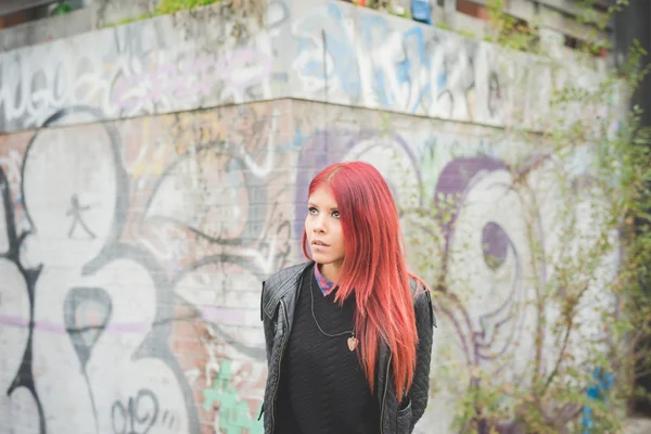 Young woman near graffiti wall — ストック写真