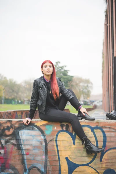 Young woman near graffiti wall — Stockfoto