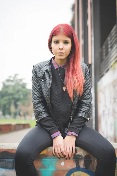 Young woman near graffiti wall — Stockfoto