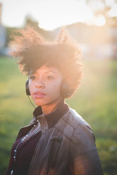 Frau mit schwarzem lockigem Haar hört Musik — Stockfoto