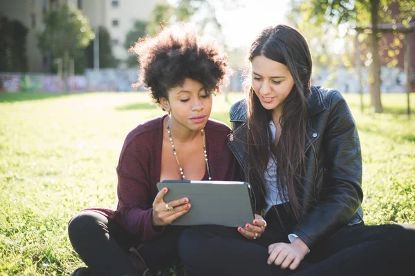 Two multiethnic women with tablet — Stock Photo, Image