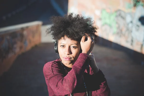 Black curly hair woman listening music — Zdjęcie stockowe