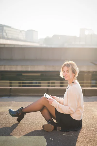 Blond kvinna utomhus med hjälp av Tablet PC — Stockfoto