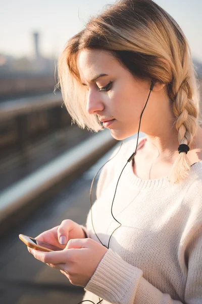 Mujer rubia escuchando música al aire libre — Foto de Stock