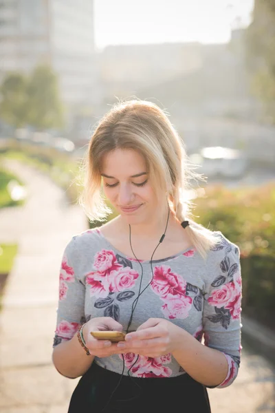 Blonde femme en plein air écoute musique — Photo