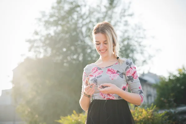 Blonde Frau im Freien Musik hören — Stockfoto